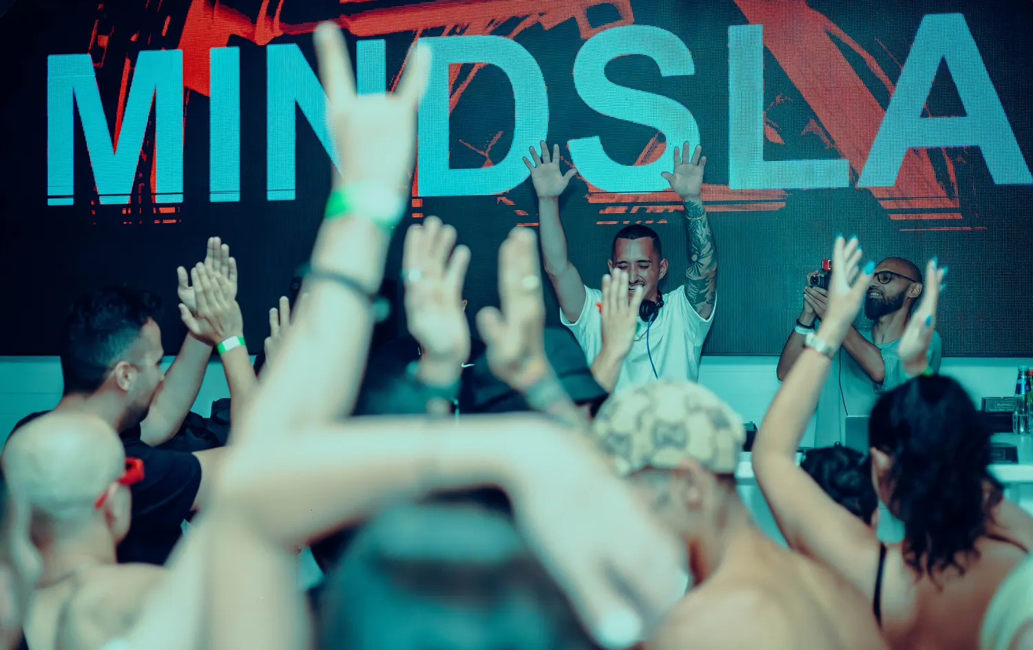 Crowd with hands in the air under a MINDSLASH banner
